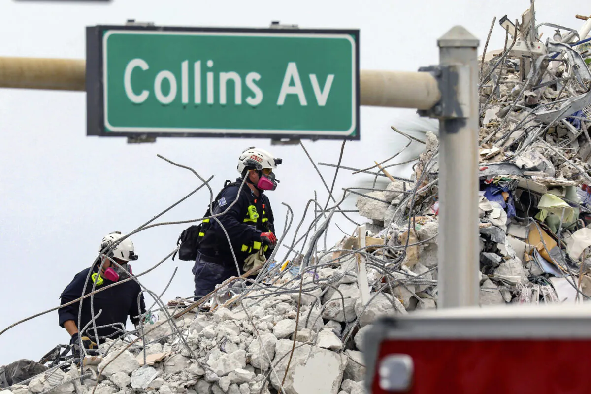 A search and rescue team members climb the rubble of the Champlain Towers South condo in Surfside, Fla., on July 7, 2021. (Al Diaz/Miami Herald via AP)