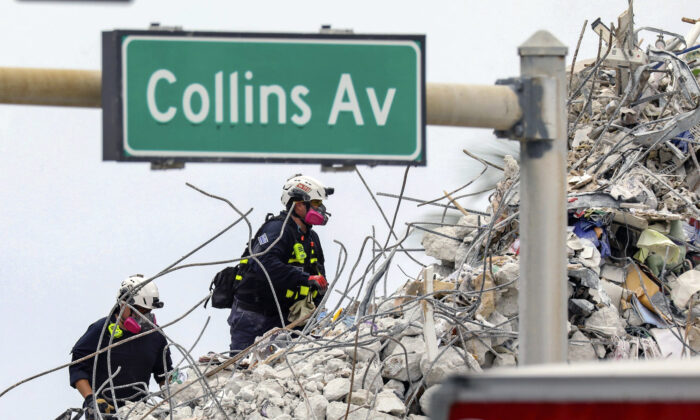 A search and rescue team members climb the rubble of the Champlain Towers South condo in Surfside, Fla., on July 7, 2021. (Al Diaz/Miami Herald via AP)