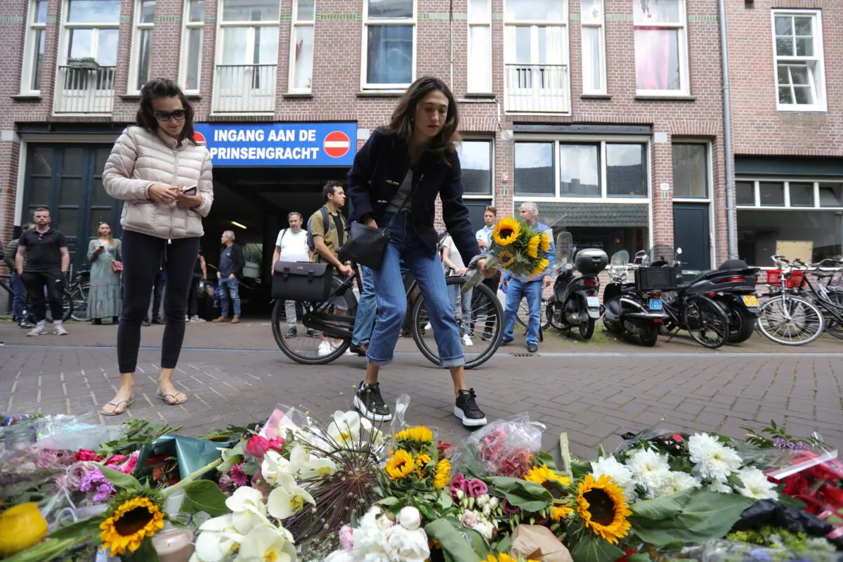 A woman leaves flowers where Dutch celebrity crime reporter Peter R. de Vries was shot and reported seriously injured in Amsterdam on July 7, 2021. (Eva Plevier/Reuters)