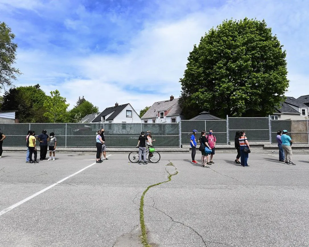 Families and youth aged 12 and older line up for a COVID-19 vaccine at Gordon A Brown Middle School in Toronto on May 19, 2021. Preliminary research suggests the COVID-19 crisis is having a sustained and significant impact on youth mental health in Ontario. (The Canadian Press/Nathan Denette)