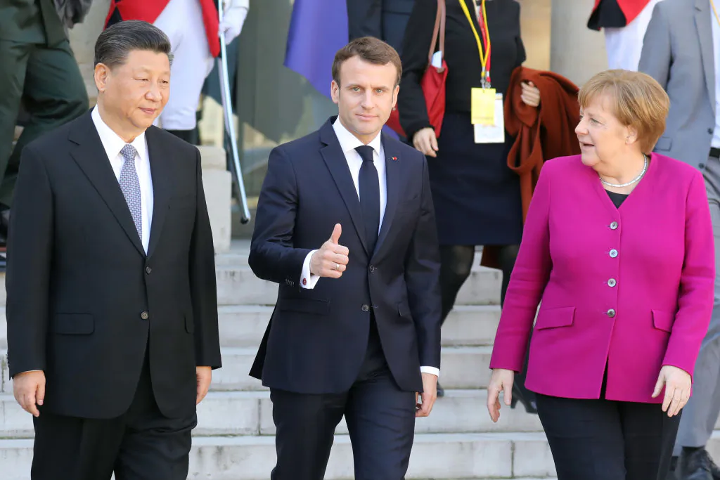 French President Emmanuel Macron (C) gestures next to German Chancellor Angela Merkel (R) and Chinese leader Xi Jinping (L) following their meeting at the Elysee Palace in Paris on March 26, 2019. (LUDOVIC MARIN/AFP via Getty Images)
