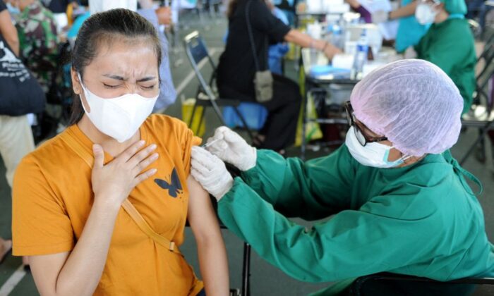 2021 年 7 月 6 日，一名妇女在印度尼西亚度假胜地巴厘岛登巴萨的临时大规模疫苗接种诊所接种了阿斯利康 COVID-19 冠状病毒疫苗。（Sonny Tumbelaka/法新社来自 Getty Images）