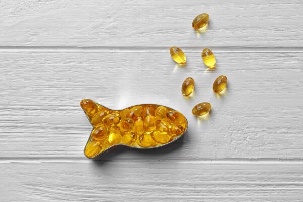 Capsules of cod liver oil arranged in a fish shape.