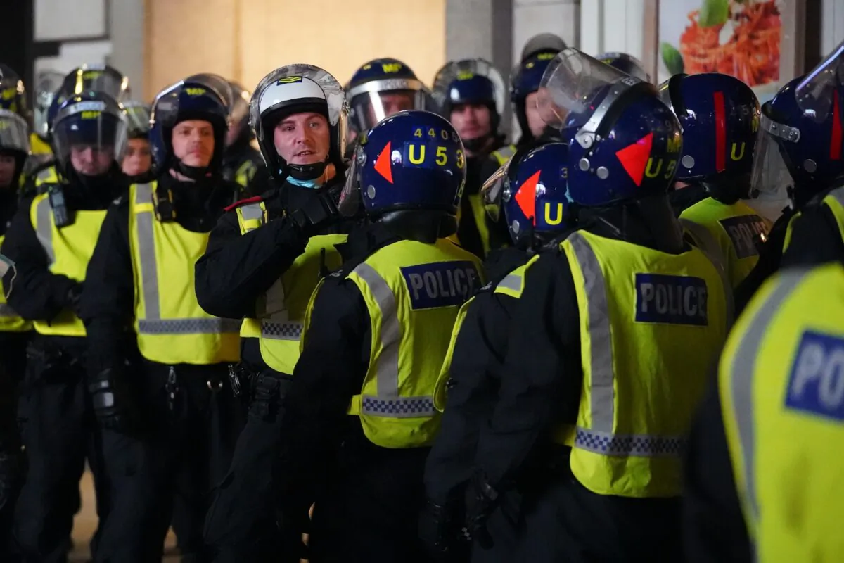 Riot police observe England fans celebrating in Piccadilly Circus, central London, on July 7, 2021. (Kirsty O'Connor/PA)