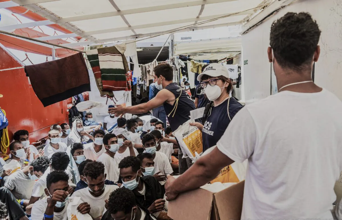 Staffers distribute food to migrants on the deck of the Ocean Viking rescue in the Mediterranean Sea, on July 5, 2021. (Flavio Gasperini/SOS Mediterranee via AP)