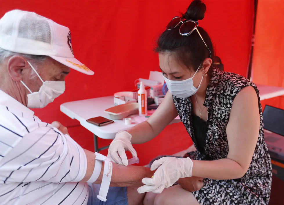 A staff member takes a blood for an antibody test in Budapest, Hungary, on July 8, 2021. (Laszlo Balogh/AP)