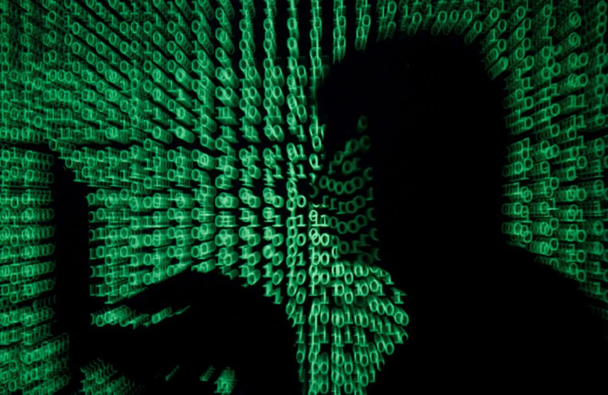 A man holds a laptop computer as cyber code is projected on him in this illustration picture taken on May 13, 2017. (Kacper Pempel/Reuters)