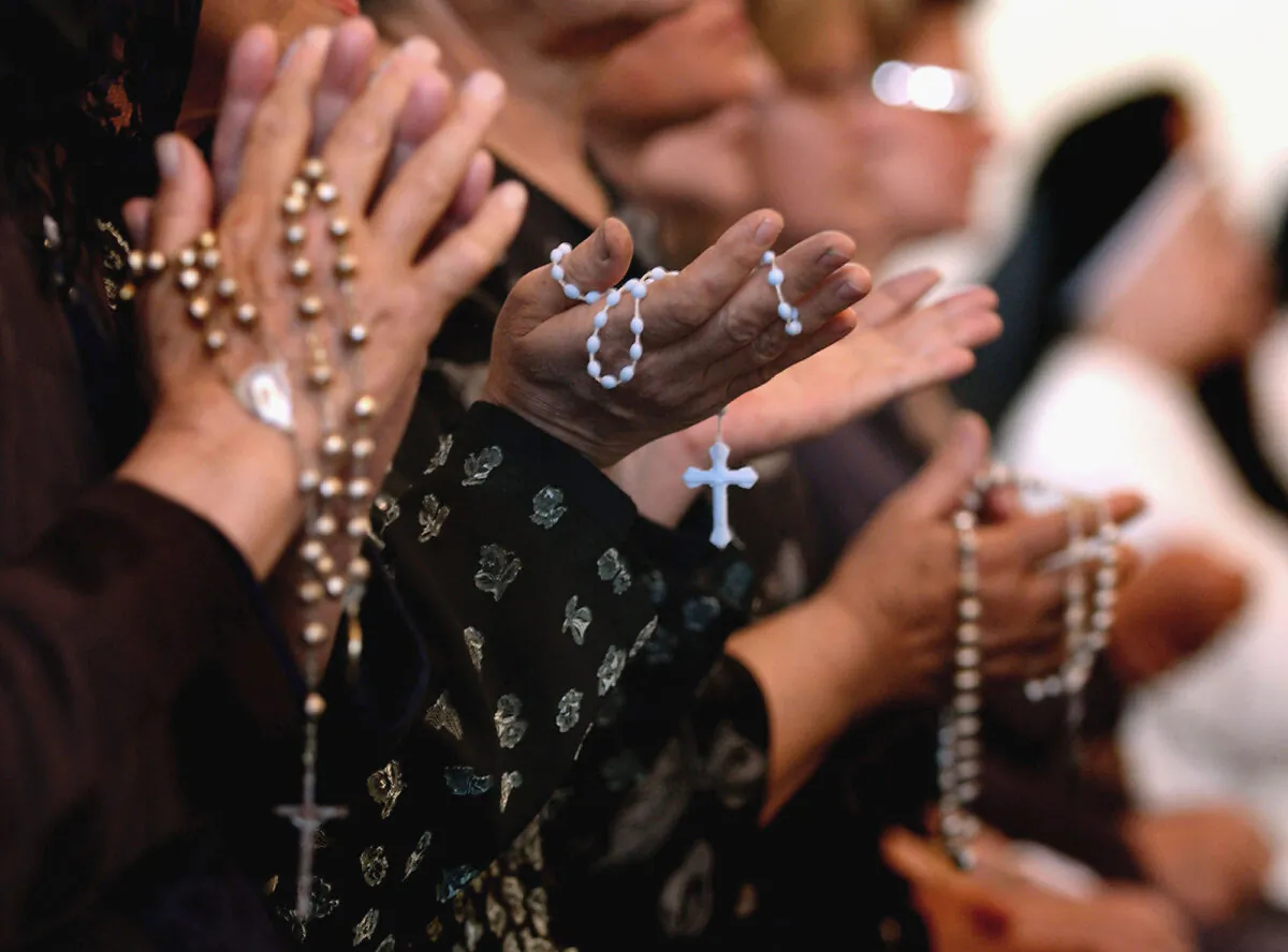 Worshippers pray at a service for Pope John Paul II at a Catholic church in Baghdad, Iraq on April, 7, 2005. (Wathiq Khuzaie/Getty Images)