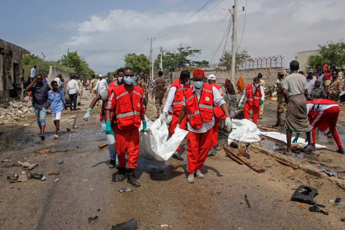 Medical workers carry the body of a civilian who was killed in a suicide car bomb attack that targeted the city's police commissioner in Mogadishu, Somalia, on July 10, 2021. (Farah Abdi Warsameh/AP Photo)