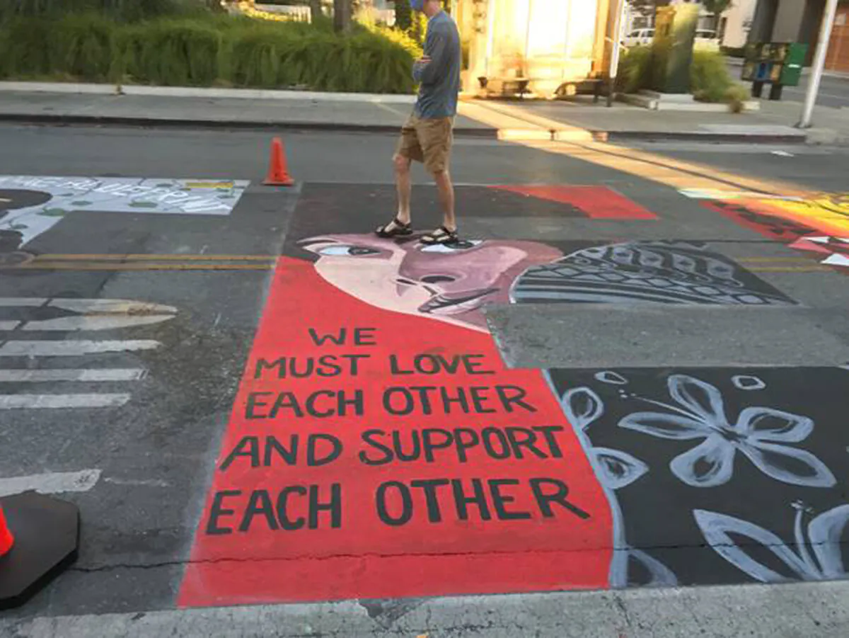 A man walks by a Black Lives Matter mural showing Joanne Chesimard, aka Assata Shakur, who was convicted of killing a New Jersey law enforcement officer in 1973, in Palo Alto, Calif., on July 8, 2020. (Dave Price/Palo Alto Daily Post via AP)