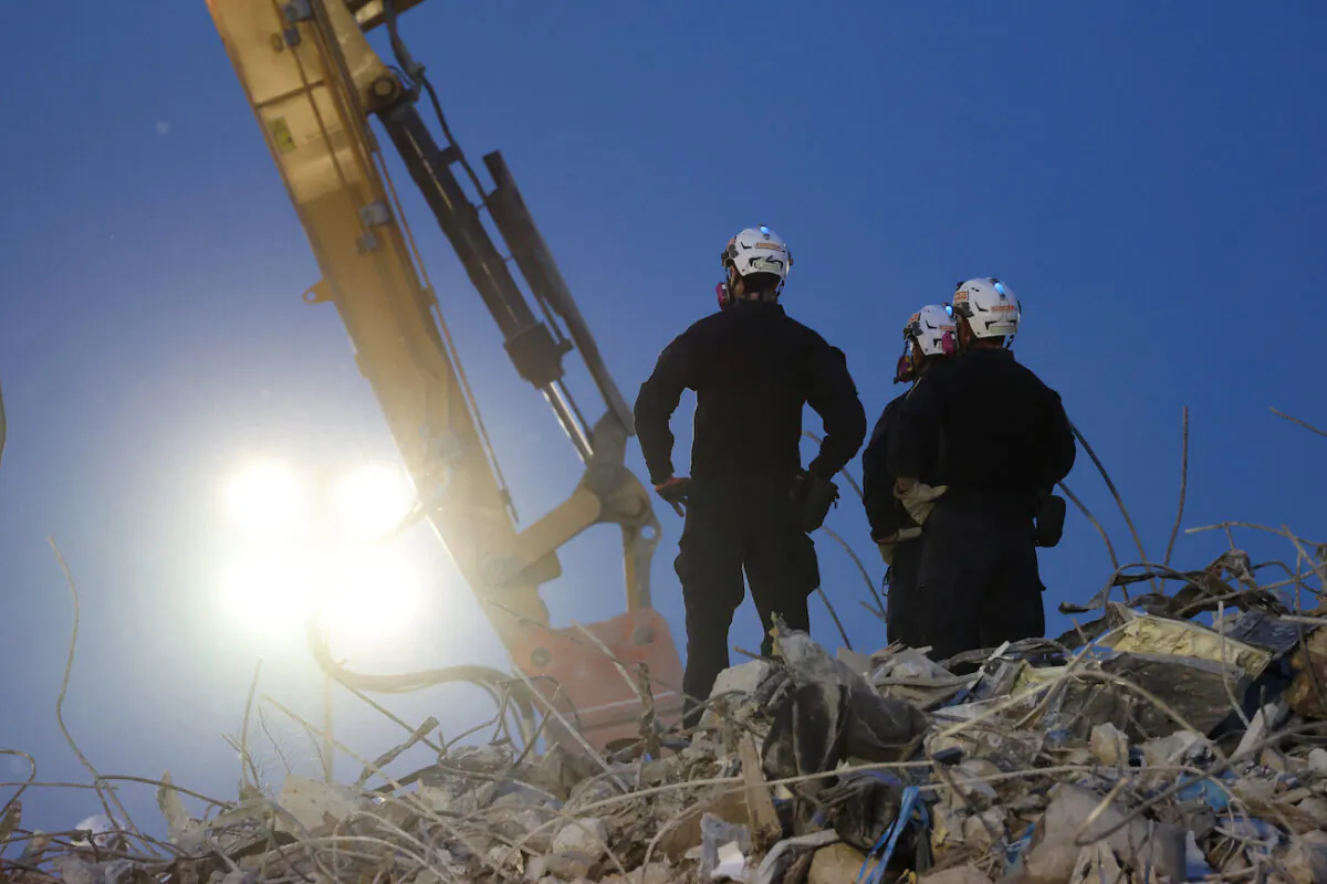 Search and rescue workers oversee an excavator dig through the rubble of the collapsed 12-story Champlain Towers South condo building in Surfside, Florida on July 9, 2021. (Anna Moneymaker/Getty Images)