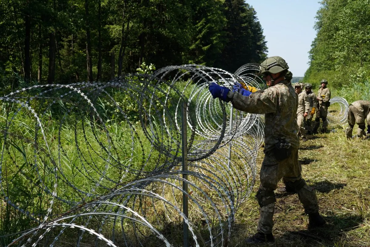Lithuanian army soldiers install razor wire on border with Belarus in Druskininkai, Lithuania, on July 9, 2021. (Janis Laizans/Reuters)