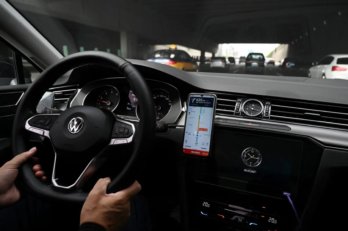 A driver uses the map on the DiDi Chuxing ride-hailing app on his smartphone while driving on a street in Beijing on July 5, 2021. (GREG BAKER/AFP via Getty Images)
