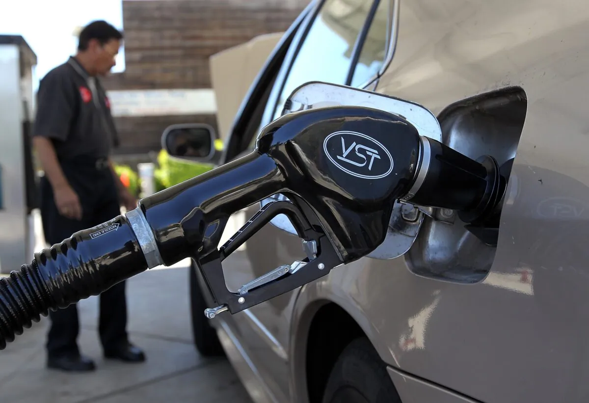 A gasoline pump rests in the tank of a car, in San Anselmo, Calif., on 12 June, 2012. (Justin Sullivan/Getty Images)