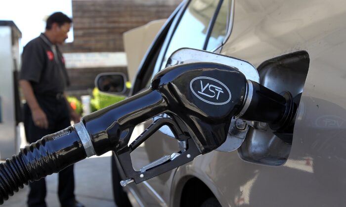 A gasoline pump rests in the tank of a car, in San Anselmo, Calif., on 12 June, 2012. (Justin Sullivan/Getty Images)
