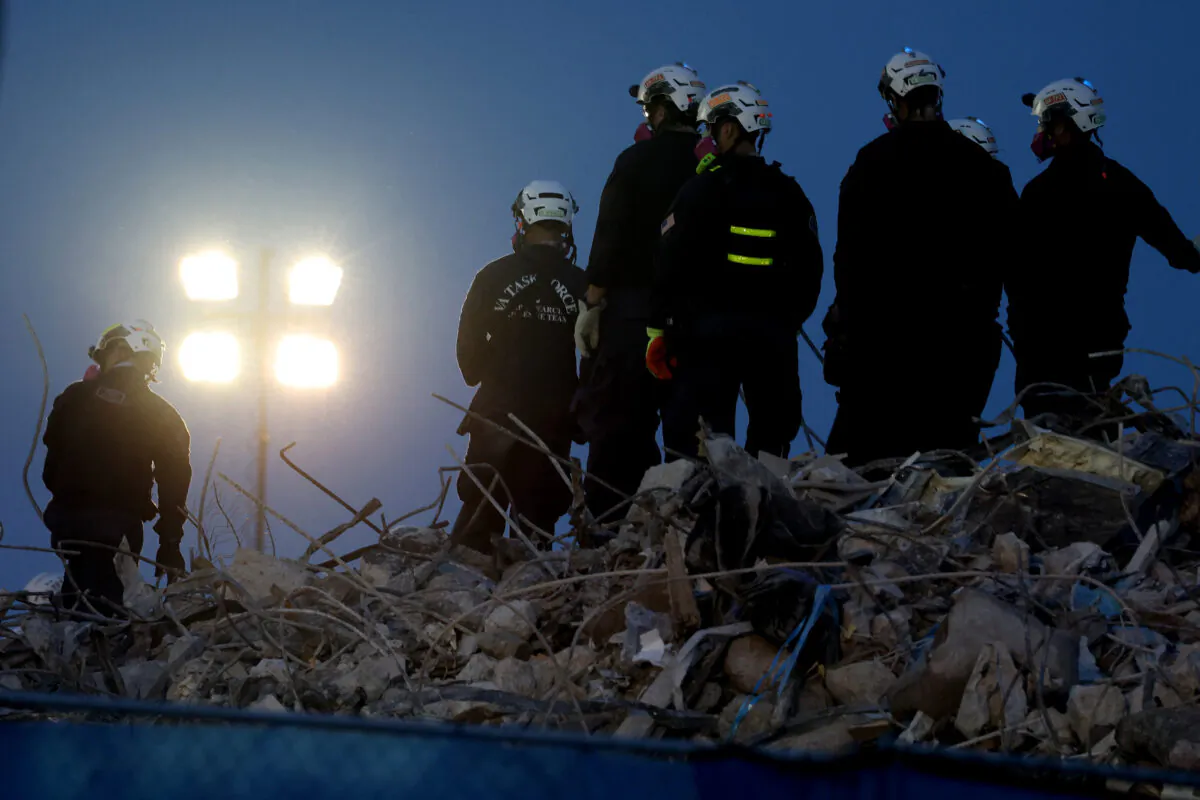 Search and rescue workers oversee an excavator dig through the rubble of the collapsed 12-story Champlain Towers South condo building in Surfside, Fla., on July 9, 2021. (Anna Moneymaker/Getty Images)