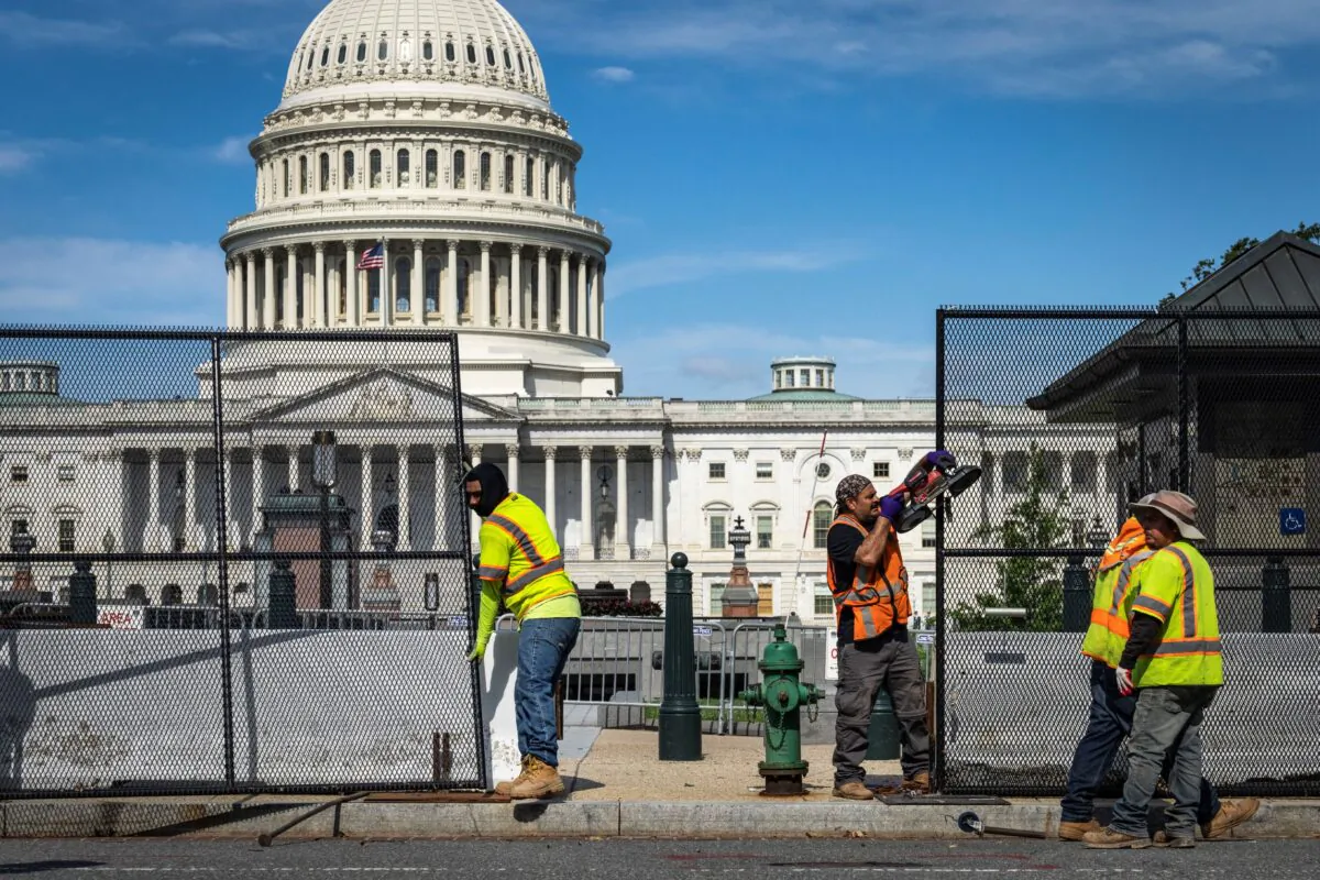 Workers remove security fencing surrounding the U.S. Capitol in Washington, on July 10, 2021. (Drew Angerer/Getty Images)