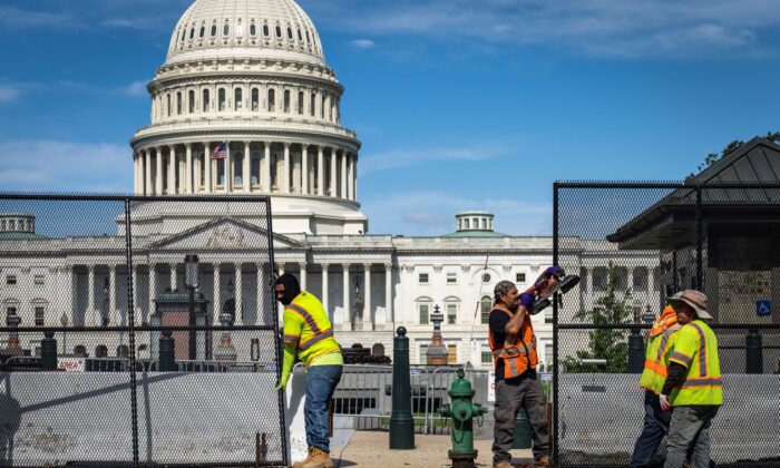 Workers remove security fencing surrounding the U.S. Capitol in Washington, on July 10, 2021. (Drew Angerer/Getty Images)