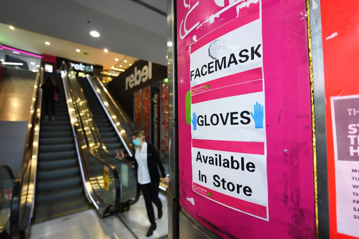 Signage for facemarks and gloves are seen at an entrance to a Priceline Pharmacy in Melbourne, Australia on July 20, 2020. (AAP Image/James Ross)