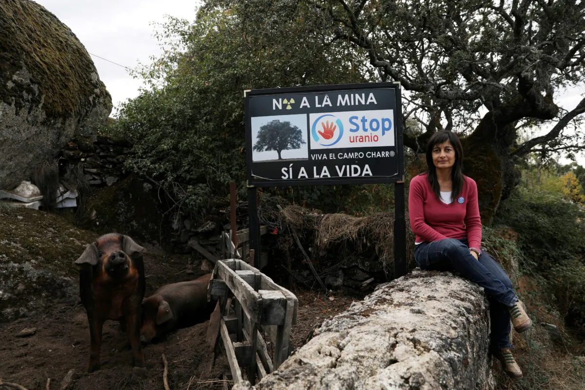 Raquel Romo, 44, a member of the "Stop Uranium" group, poses near a sign that reads "Stop Uranium. No to the mine, yes to life" outside her parent's house near the site of a planned open-cast uranium mine by Australian mining company Berkeley Energia in the village of Retortillo, near Salamanca, Spain, on Oct. 17, 2018. (Susana Vera/Reuters)