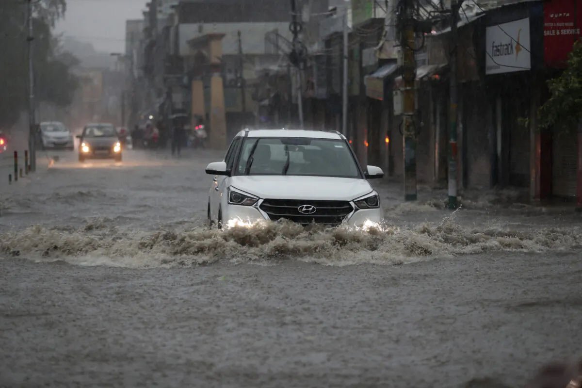 Vehicles move through a flooded road after a heavy rainfall in Jammu, India, Monday, July 12, 2021. (AP Photo/Channi Anand)