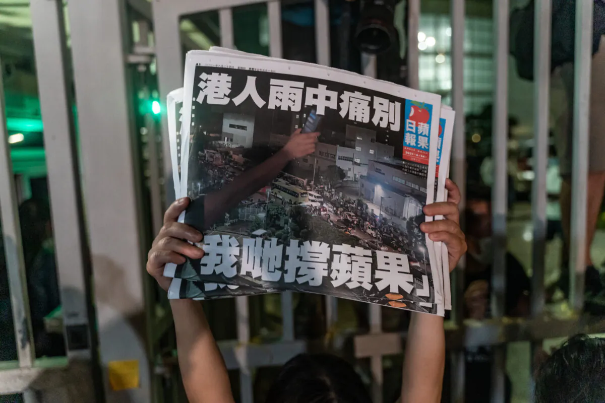 An employee holds up the latest copies of the Apple Daily newspaper outside at the offices in Hong Kong,  on June 24, 2021. (Anthony Kwan/Getty Images)