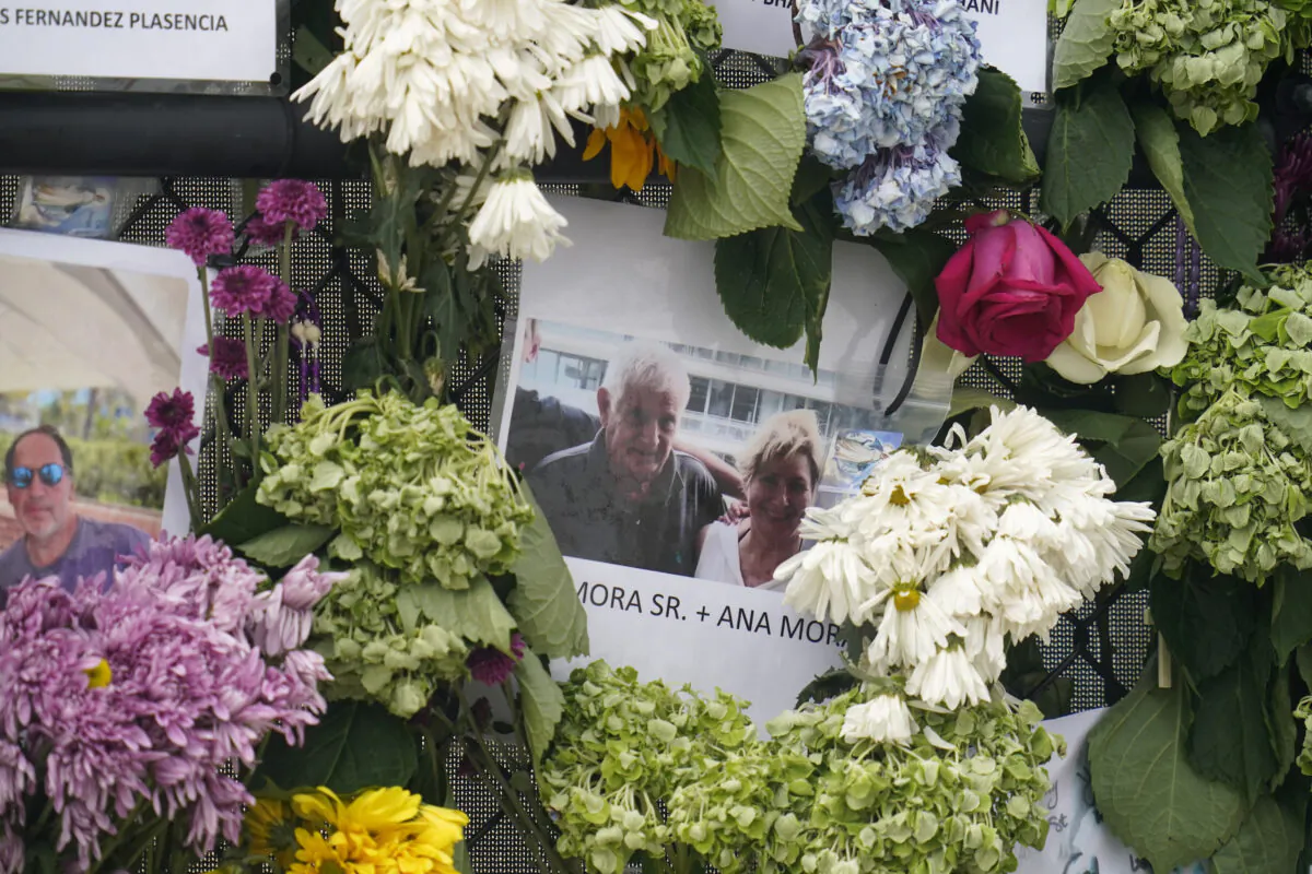 A memorial wall for the victims of the Champlain Towers South building collapse in Surfside, Fla., with a photo of Juan Mora Sr. and his wife, Ana Mora, on June 29, 2021. (Gerald Herbert/AP Photo)
