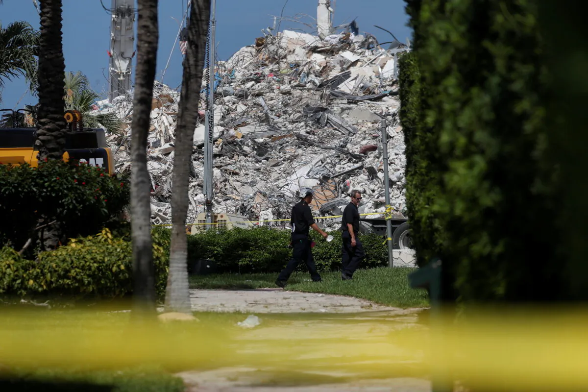 Search teams walk by the remains of the Surfside's Champlain Towers South condominium in Miami on July 8, 2021. (Shannon Stapleton/Reuters)