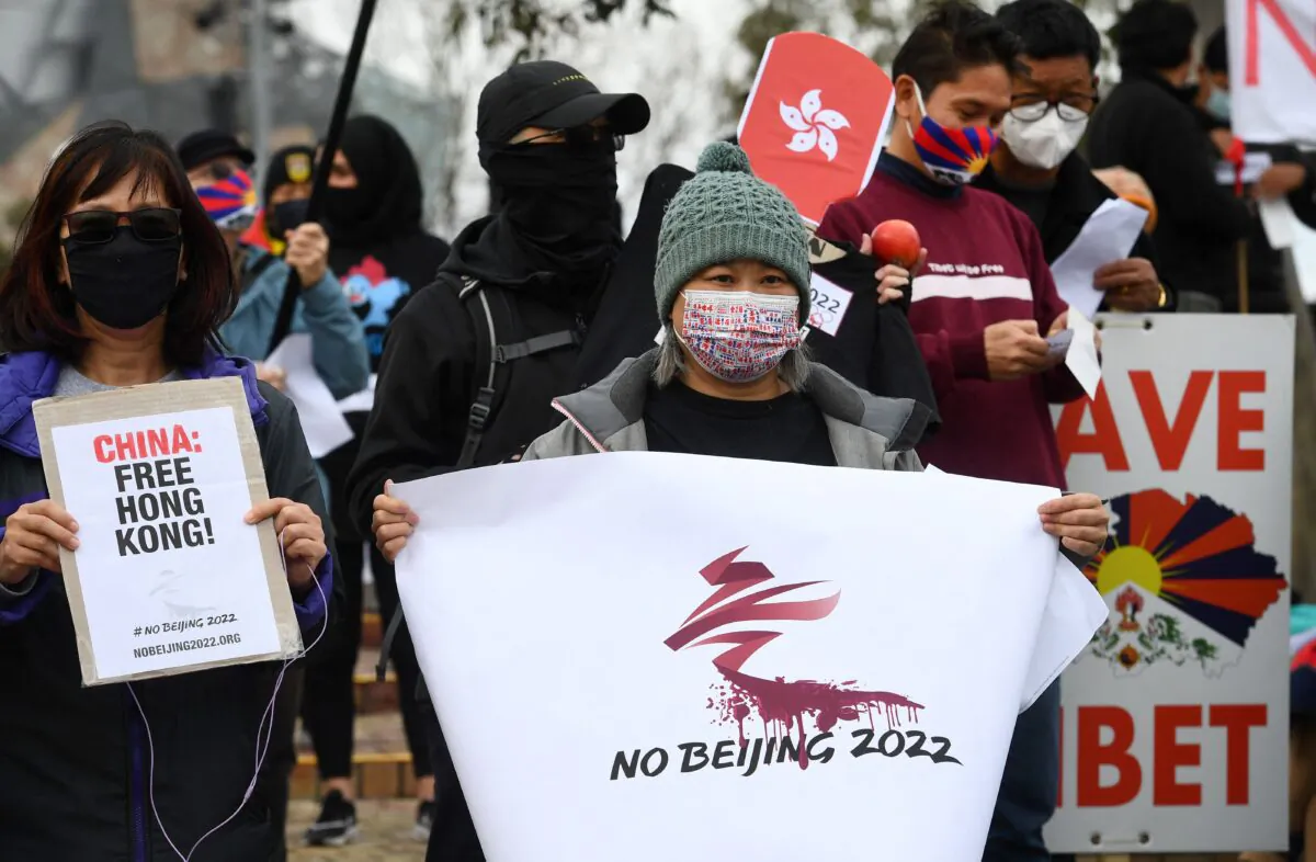 Activists including members of the local Hong Kong, Tibetan and Uyghur communities hold up banners and placards in Melbourne, Australia, on June 23, 2021, calling on the Australian government to boycott the 2022 Beijing Winter Olympics over China's human rights record. (William West/AFP via Getty Images)