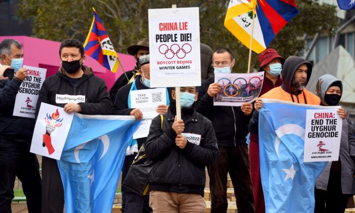 Activists, including members of the local Hong Kong, Tibetan, and Uyghur communities, hold up banners and placards calling on the Australian government to boycott the 2022 Beijing Winter Olympics over China's human rights record, in Melbourne, Australia, on June 23, 2021. (William West/AFP via Getty Images)
