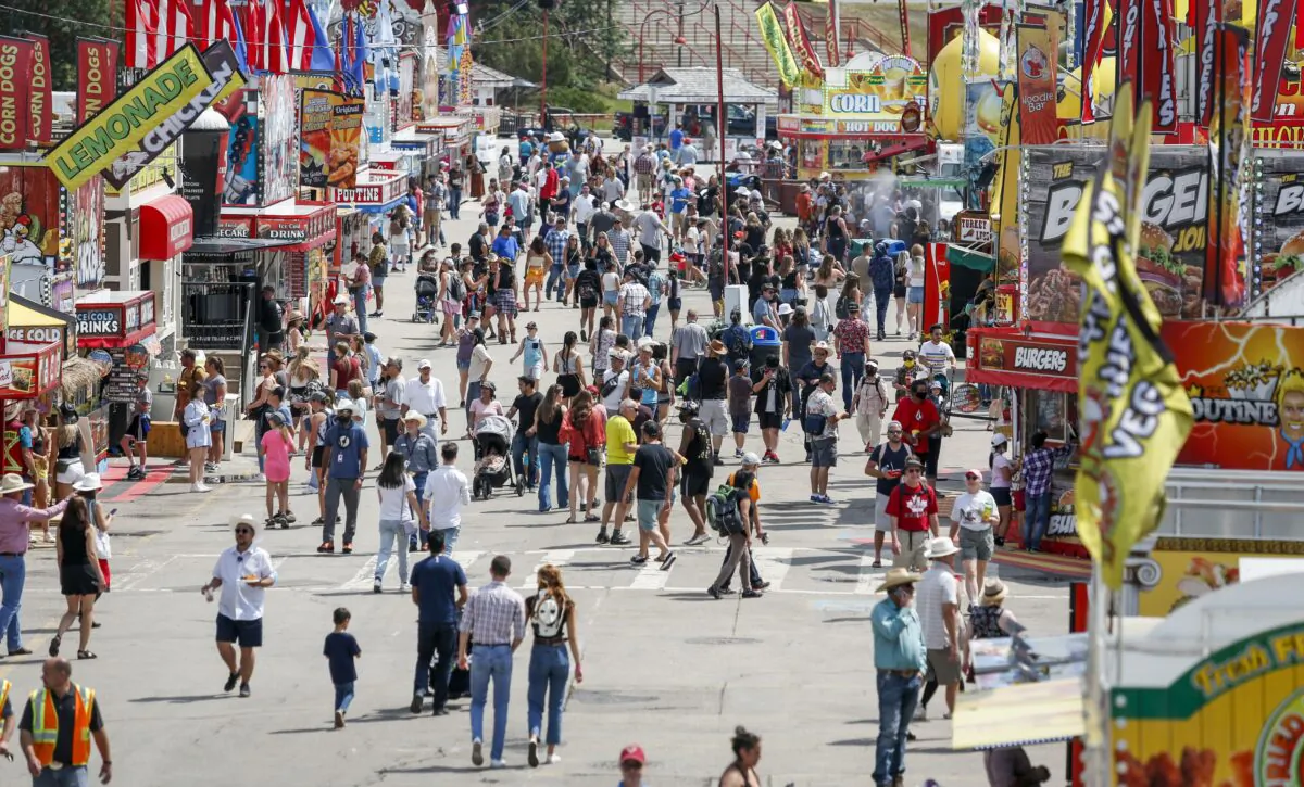 Crowds meander through Stampede Park on the first day of the Calgary Stampede in Calgary on July 9, 2021. (The Canadian Press/Jeff McIntosh)