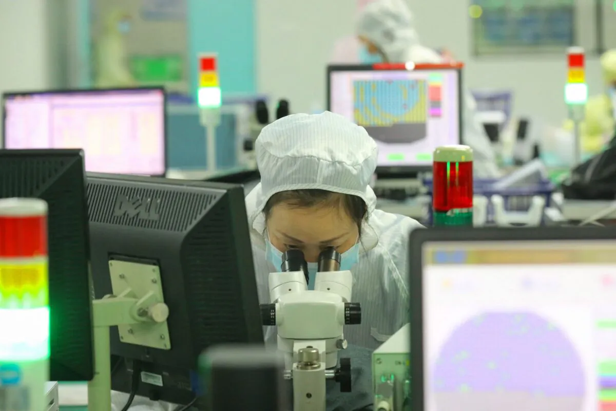 An employee makes chips at a factory of Jiejie Semiconductor Co. in Nantong, in China's Jiangsu Province, on March 17, 2021.   (STR/AFP via Getty Images)