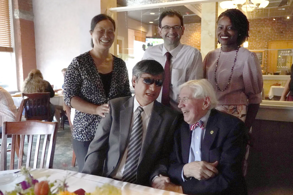 Chen Guangcheng (front left) laughs with his wife, Weijing Yuan (top left) and his legal team, Enrique Mesa, Jr. (top middle), Lina Shayo (top right), and George Bruno (front right) during a lunch to celebrate his citizenship, in Manchester, N.H., on July 8, 2021. (AP Photo/Elise Amendola)