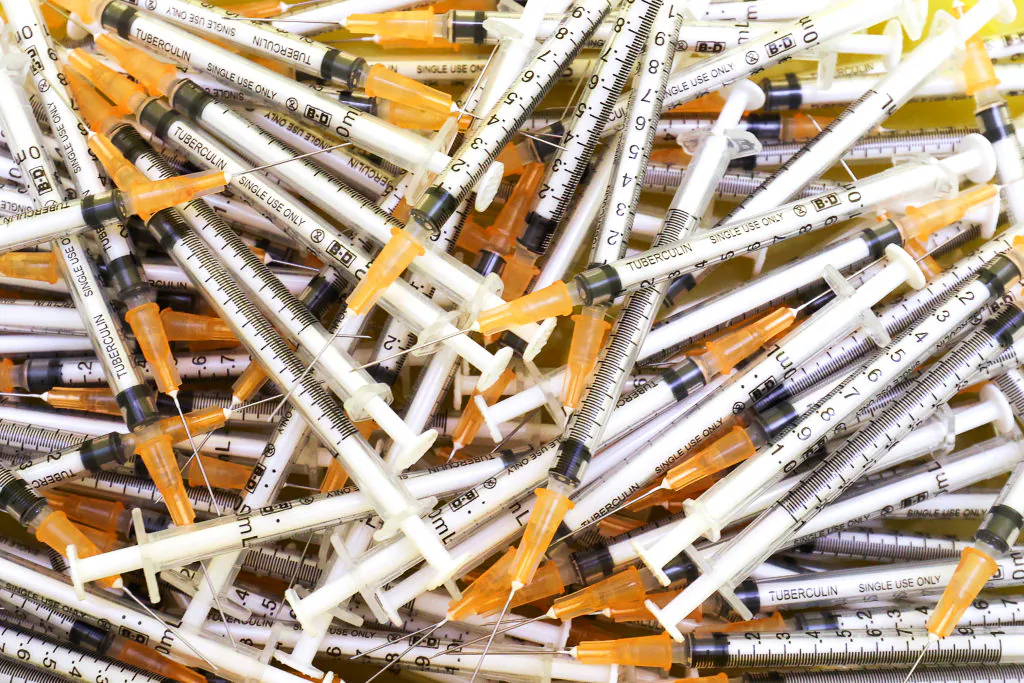 Needles from previous vaccine injections are seen in a biohazard container in New Zealand, on March 30, 2021. (Hagen Hopkins/Getty Images)