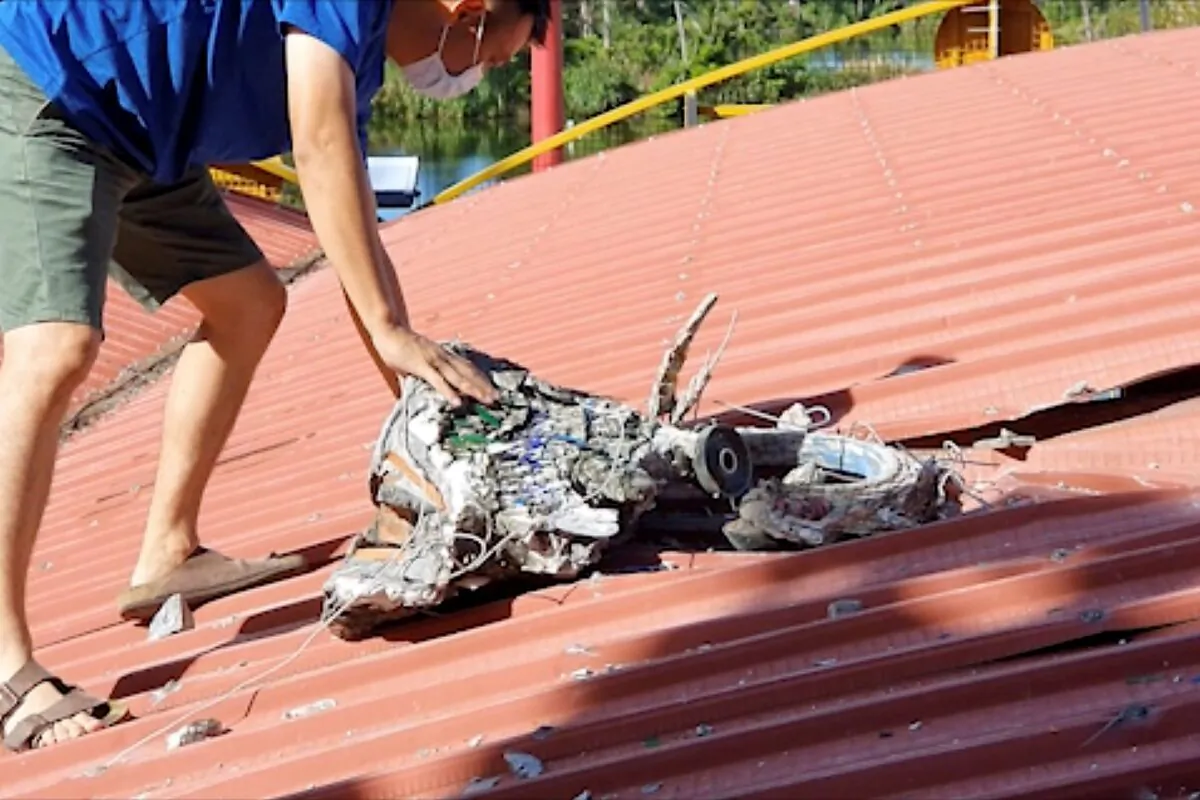 In this image taken from a video footage run by Taiwan's TTV via AP Video, a man checks the roof of a temple where a decorative piece fell and damaged the roof after multiple earthquakes struck the city of Hualien along the eastern coast of Taiwan, on July 14, 2021. (TTV via AP)