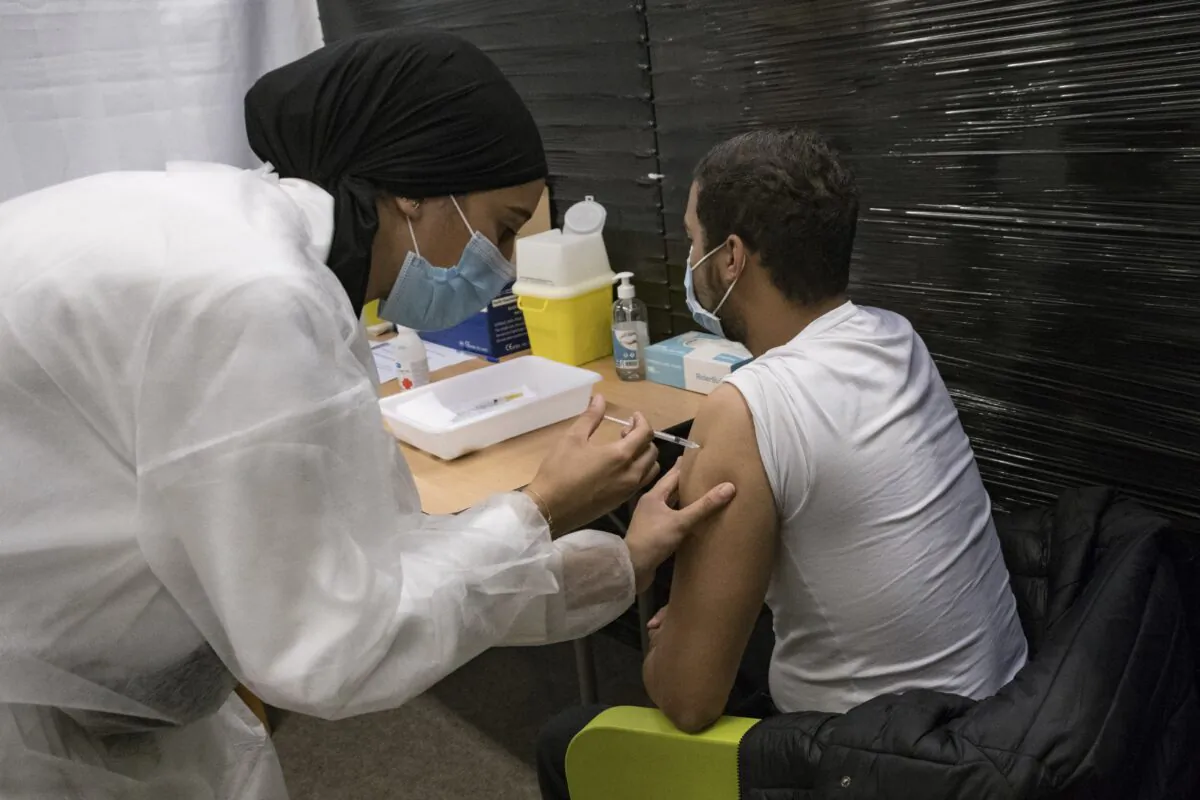 A nurse administrates the Pfizer COVID-19 vaccine to Thibaut Razafinarivo, 26, in a vaccination center in Versailles, west of Paris, on July 13, 2021. (Constantin Gouvy /AP Photo)