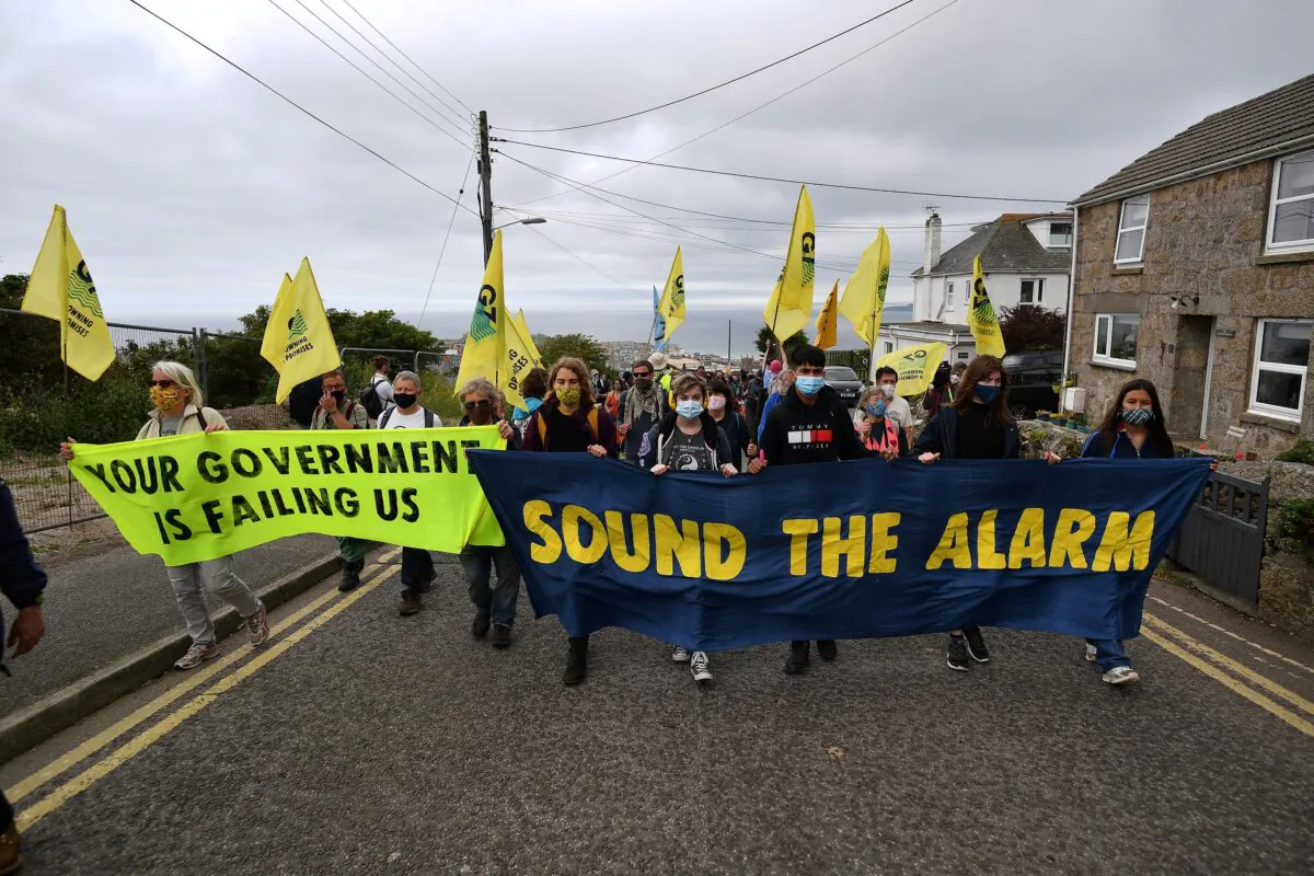 Activists from the climate change protest group Extinction Rebellion take part in a protest march  on the first day of the three-day G7 summit in St Ives, Cornwall, England, on June 11, 2021. (Ben Stansall/AFP via Getty Images)