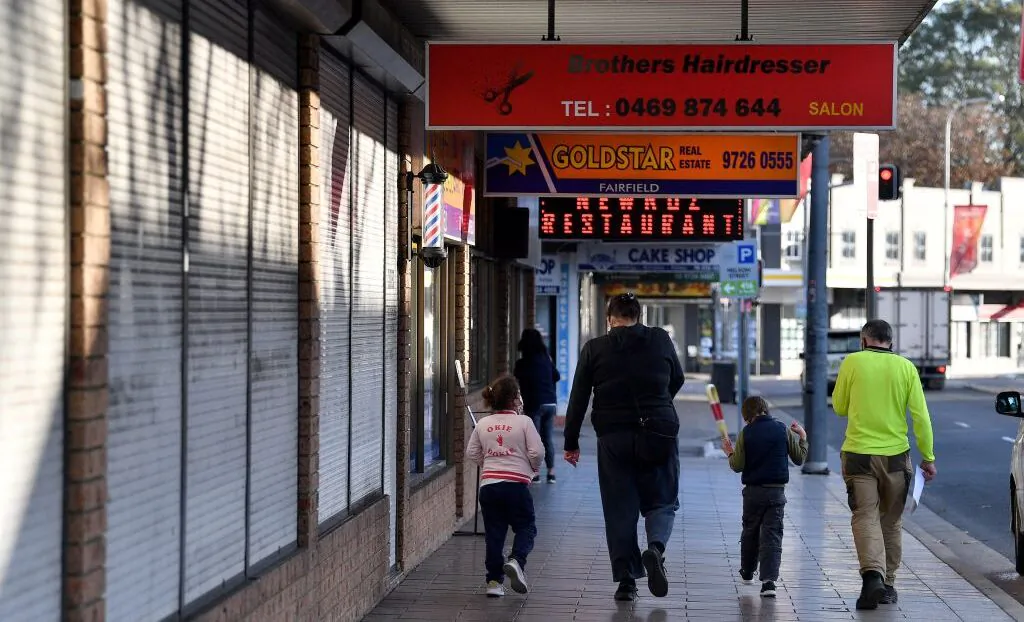 A family walk in front of shuttered shops during a lockdown in the Fairfield in Sydney, Australia, on July 12, 2021. (Saeed Khan/AFP via Getty Images)