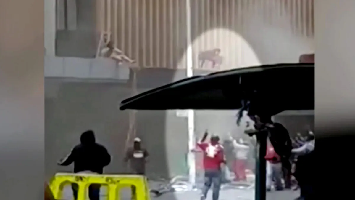 In this still image from a video obtained by Reuters, a mother throws her baby into a crowd of people on the street, in Durban, South Africa, on July 13, 2021. (Reuters/Screenshot via NTD)