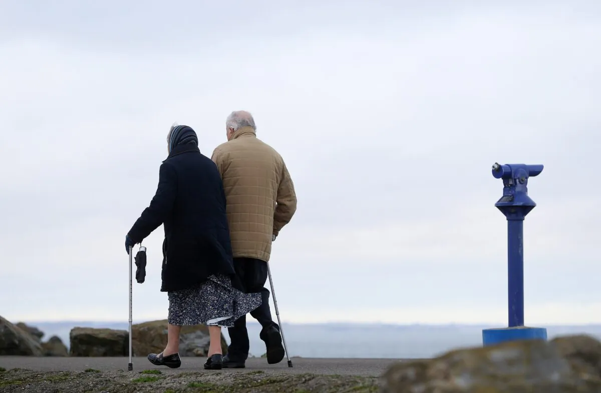 An elderly couple walking at unknown venue on Dec. 21, 2020. (Brian Lawless/PA)
