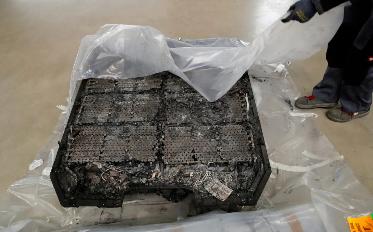A technician unpacks a completely burned Lithium-ion car battery before its dismantling by the German recycling firm Accurec in Krefeld, Germany, November 16, 2017.  (REUTERS/Wolfgang Rattay/File Photo)