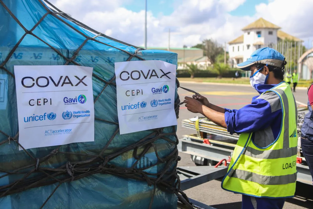 A worker handles boxes of Oxford/AstraZeneca COVID-19 vaccines, part of the the Covax programme, which aims to ensure equitable access to COVID-19 vaccinations, after they were flown into the Ivato International Airport in Antananarivo, Madagascar on May 8, 2021. (Mamyrael/AFP via Getty Images)
