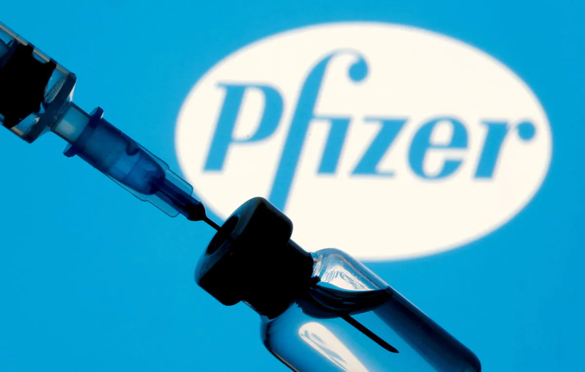 A vial and syringe are seen in front of a displayed Pfizer logo in this illustration taken on Jan. 11, 2021. (Reuters/Dado Ruvic/Illustration/File Photo)