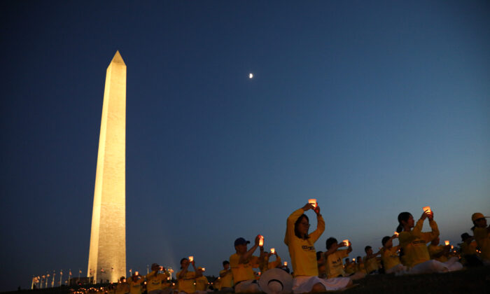 Falun Gong practitioners take part in a candlelight vigil remembering victims of the 22-year-long persecution in China at the Washington Monument on July 16, 2021. (Samira Bouaou/The Epoch Times).