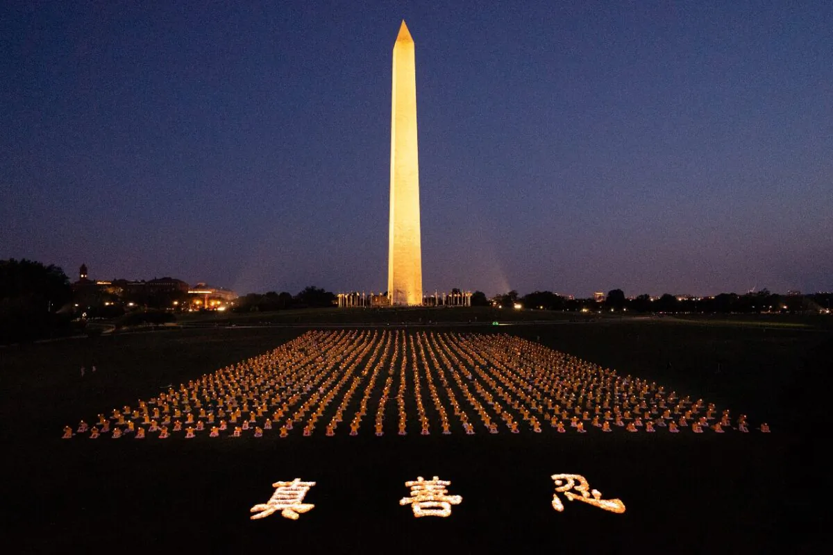 Falun Gong practitioners hold a candlelight vigil remembering victims of the persecution in China, now in its 23rd year, at the Washington Monument on July 16, 2021. The characters for "Truthfulness, Compassion, Tolerance," the principles taught by the spiritual practice, appear at the front. (Edward Dai/The Epoch Times)