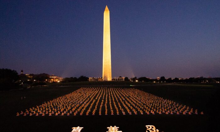 Falun Gong practitioners at candlelight vigil remembering victims of the 22 years persecution in China at the Washington Monument on July 16, 2021. The characters for "Truthfulness, Compassion, Tolerance," the principles taught by the spiritual practice appear at the front. (Edward Dai/The Epoch Times)