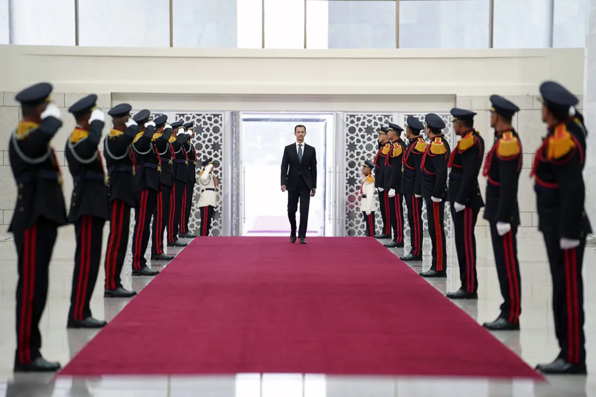 Syrian President Bashar Assad, reviews an honor guard at the Syrian Presidential Palace in the capital Damascus, Syria, on July 17, 2021. (Syrian Presidency via Facebook via AP)