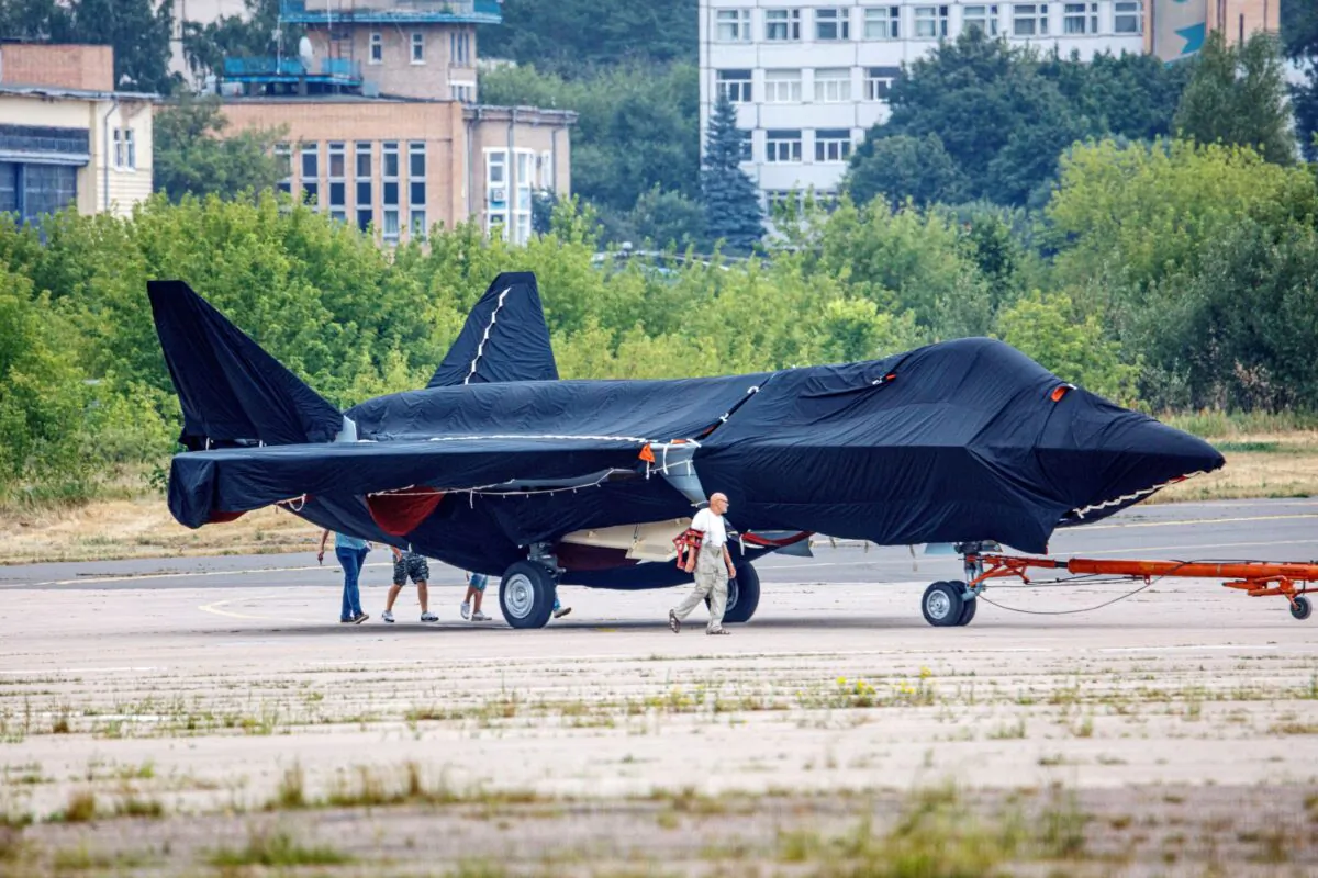 Hidden under tarpaulin, a prospective Russian fighter jet is being towed to a parking spot before its presentation at the Moscow international air show in Zhukovsky outside Moscow, Russia, on July 15, 2021. (Ivan Novikov-Dvinsky/AP Photo)