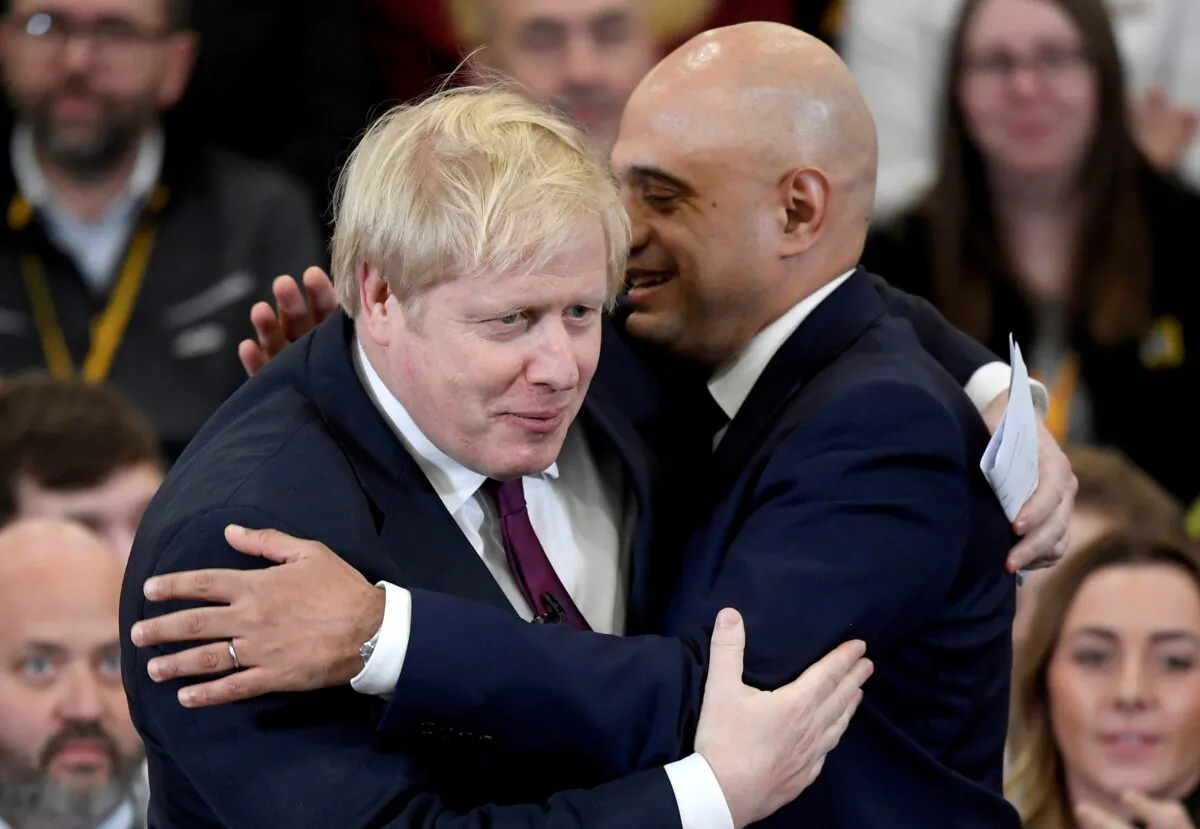 Britain's Prime Minister Boris Johnson is embraced by Britain's Chancellor of the Exchequer Sajid Javid before speaking to the workers as he visits a JCB factory during his general election campaign in Uttoxeter, Britain, on Dec. 10, 2019. (Toby Melville/Reuters)