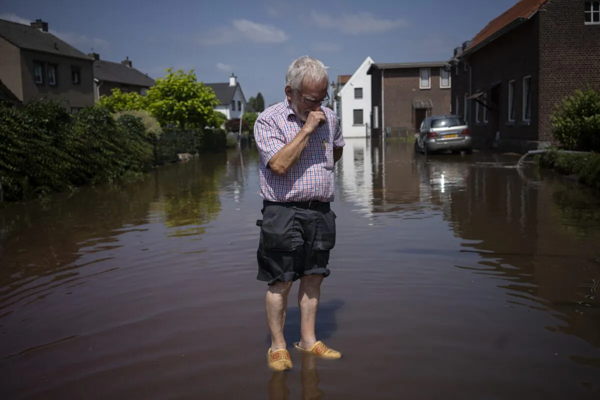 Wiel de Bie, 75, stands outside his flooded home in the town of Brommelen, Netherlands, Saturday, July 17, 2021. (Bram Janssen/AP Photo)